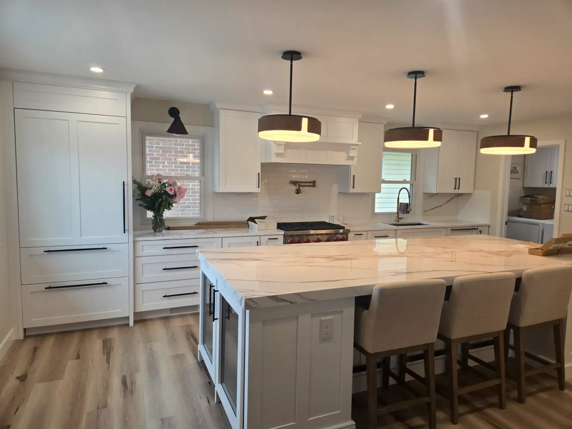 White stone island with pendant lights and stools